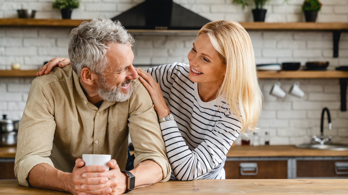 Man and woman sitting together in a kitchen, smiling with their new VIVA21 ro system