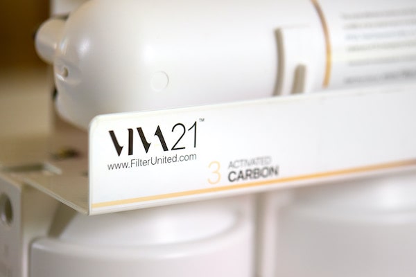 Close-up of a white filter with 'VIVA21' branding on a blurred background