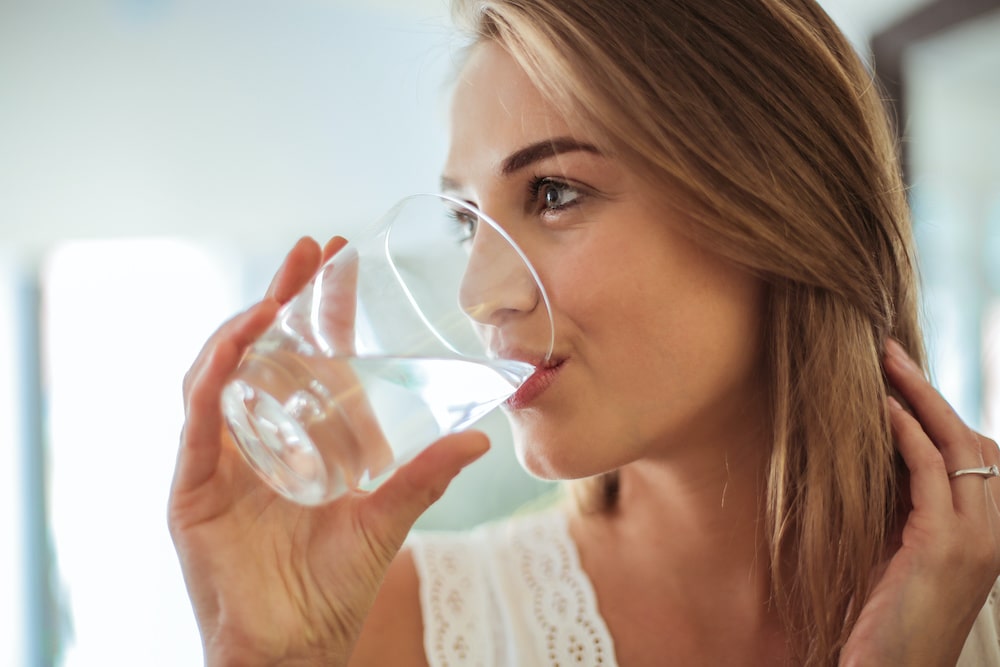 Woman drinking water from a glass indoors